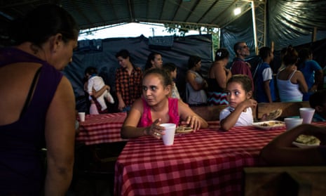 People have dinner at the shelter for the displaced community of El Castaño.
