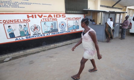 A woman walks past Aids information on a wall in New Kru Town near Monrovia, Liberia