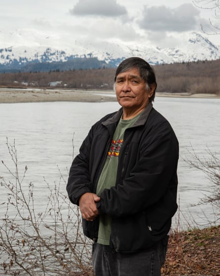 Jones Hotch, Klukwan elder on the banks of the Chilkat River with the village of Klukwan in the distance