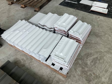 A stack of recycled roof tiles and steel panels painted with a water-based cool coating
