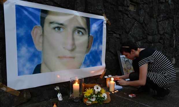 A woman lights a candle for Reza Barati during a vigil in support of asylum seekers in Brisbane, 23 February 2014. 