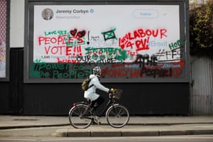 A cyclist passes an image of a blank mock tweet by Jeremy Corbyn, covered in anti-Brexit and Peopleâs Vote graffiti, in north London