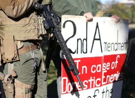 A man carries a rifle as militia members and pro-gun rights activists participating in a “Declaration of Restoration” rally prepare to march to Washington DC from Arlington, Virginia, on 9 November.