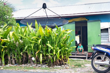 A young Tuvaluan boy sits outside a typical home in downtown Funafuti.