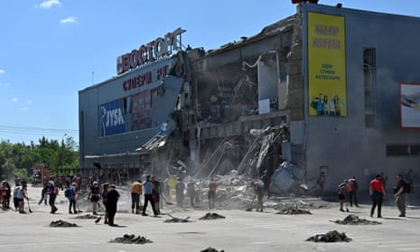 Communal workers clean up the rubble of a supermarket, partially destroyed by a missile attack on the southeastern outskirts of the Ukrainian city of Kharkiv.
