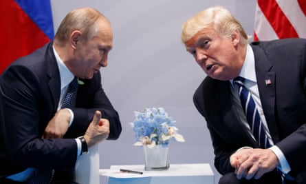 Vladimir Putin, sitting before a Russian flag, leans in to talk to Donald Trump, who is sitting before an American flag.