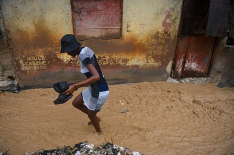 A woman walks along a flooded street after heavy rains caused by the outer bands of Hurricane Melissa flooded some areas, in Port-au-Prince, Haiti, October 29, 2025.