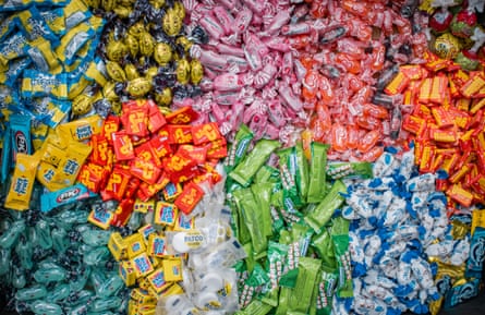 Piles of brightly coloured sweets, all wrapped in plastic, seen from above