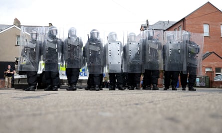 Riot police form a line on the Lower Ormeau road after protesters make their way through the area following a protest outside Belfast City Hall.