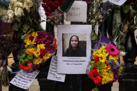 Flowers are tied to the gates along with a photo of Jason Arday