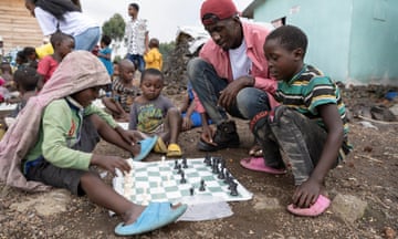 Gabriel Nzaji teaches internally displaced Congolese children the rules of  chess rules as part of the Chess in the City initiative at Focus Congo site in Kibati