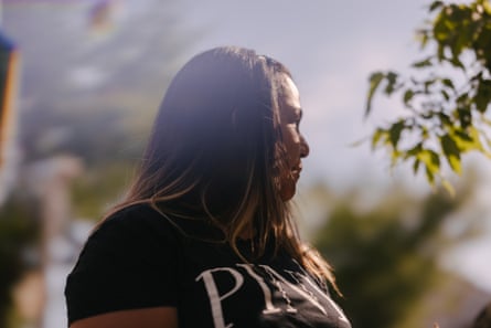 A woman, whose look is turned for privateness reasons, stands for a image betwixt trees