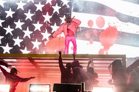 man on stage in front of giant US flag
