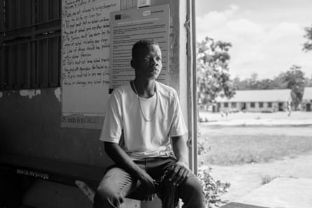 a teenage boy sits in a school