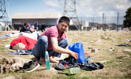 A refugee washes his clothes at a camp in Calais, France.