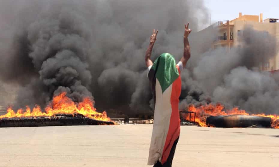 A protester in front of burning tyres and debris near Khartoum’s army headquarters.
