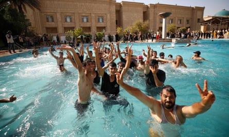 Supporters of Moqtada al-Sadr swim in the pool of the government headquarters in Baghdad on Monday