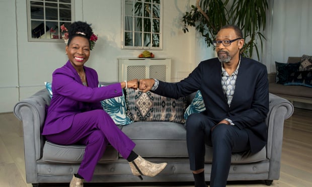 Floella Benjamin and Lenny Henry bumping fists on a sofa