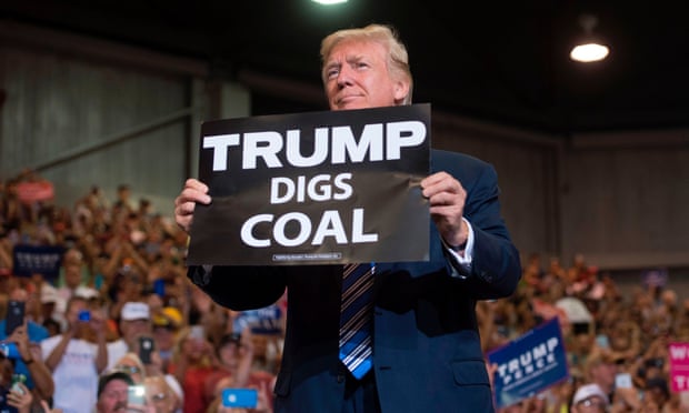 Donald Trump holds a sign saying Trump Digs Coal
