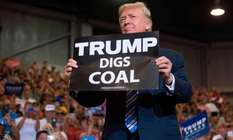 Donald Trump holding a sign reading Trump Digs Coal