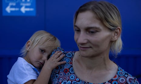Tatiana Pidlesina and her 2-year old daughter Ulyana wait at the Zaporizhzhia relief centre, where volunteers provide food and transportation for those who are not travelling on their own, to be transferred to other parts of the country.