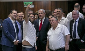 Knesset member Oren Hazan takes a selfie with Benjamin Netanyahu, centre, after the session that passed the contentious bill in Jerusalem.
