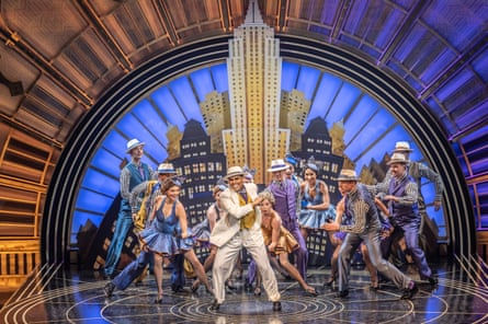 Cast dance on the revolving art deco set.
