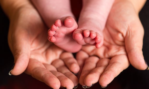 Adult hands and baby feet