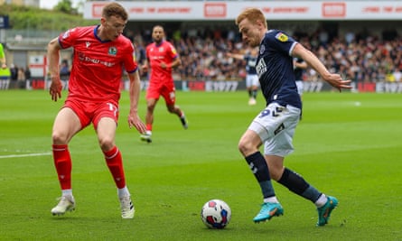 Forward Millwall Tom Bradshaw melawan Hayden Carter dari Blackburn