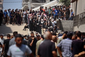 Palestinians queue at a flour distribution point