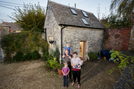 Tim Francis and his wife, Laura Hubbard-Miles, and their children – baby Edith, Tom, three, and James, five – outside their tiny home, the Fruit Store, in Gloucestershire.