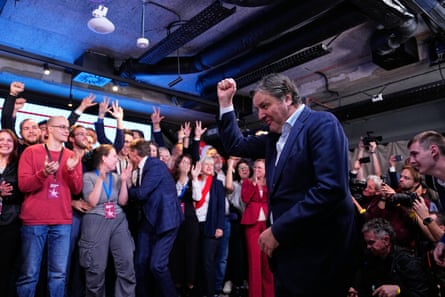 Dejan Bodiroga raises his fist, celebrating amid a cheering crowd after the election result