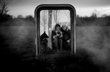 Polly Samson and musician partner Dave Gilmore are reflacted back in a mirror with their dog, in a bleak black and white landscape.