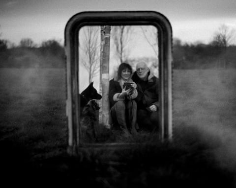Polly Samson and musician partner Dave Gilmore are reflacted back in a mirror with their dog, in a bleak black and white landscape.