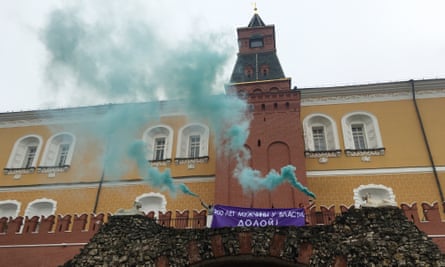 Feminist activists unfurl a banner with a message reading ‘Men have been in power for 200 years. Down with it!’ and light smoke flares outside the Kremlin on International Women’s Day.
