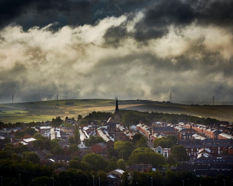 Aerial view of Oldham with moors in the background and a dark cloudy sky dqxikeidqkikdinv