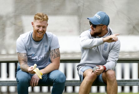 Ben Stokes on a bench eating a banana and laughing as Brendon McCullum talks in May 2022