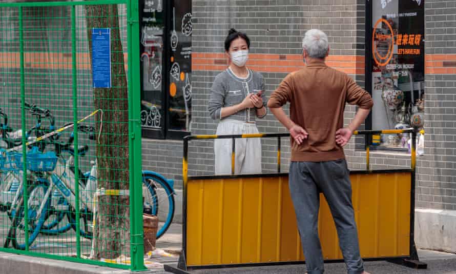 A woman in quarantine talks with a visitor during the lockdown in Shanghai