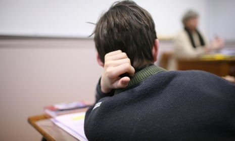 A pupil listens to a teacher in class.