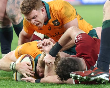 Australia’s Tate McDermott (left) scores a late try under pressure from the Lions’ Hugo Keenan