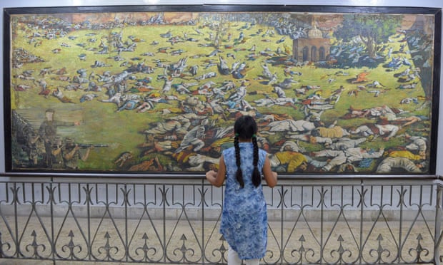 An Indian girl looks at a painting of the Jallianwala Bagh massacre.