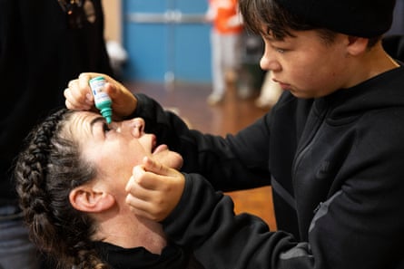 Ben puts eye drops into his mother’s eyes.