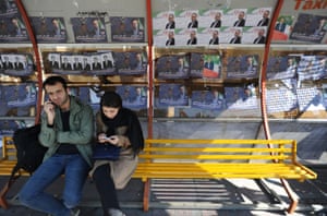 A couple waits for a bus on Vali Asr Avenue in Tehran.