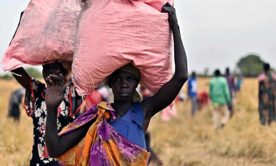 Villagers in South Sudan collect food aid dropped from a plane