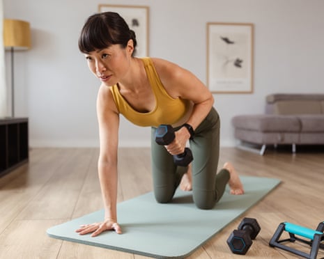 A photo of a women strength training in her home