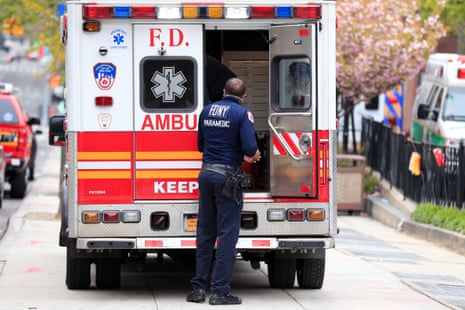 A paramedic stands outside an ambulance.