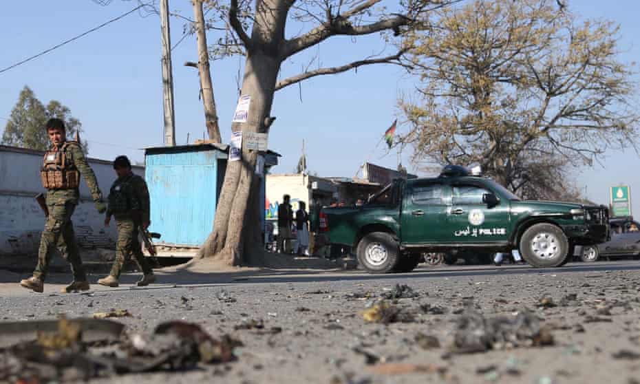 Afghan security officials inspect the scene of a roadside bomb blast last week.