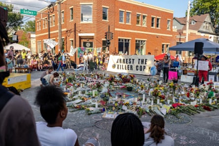 People gather near a memorial on a city street.