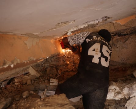 A man works on retrieving casualties from under rubble in the Tanaguarena neighbourhood