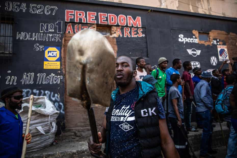 A man brandishes a shovel during the riots